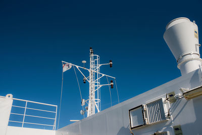 Low angle view of communications tower against clear blue sky