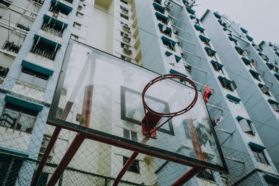 Low angle view of basketball hoop against buildings