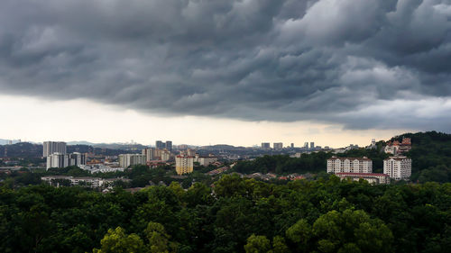 Buildings in city against cloudy sky
