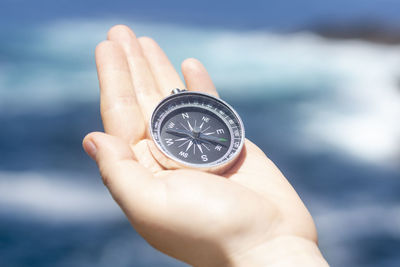 Cropped hand holding navigational compass