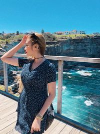 Woman standing on pier over sea