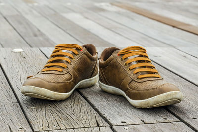 Close-up of brown shoe on wooden platform
