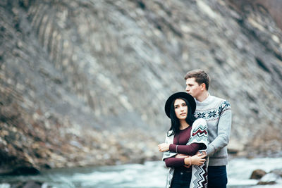 Portrait of young couple standing on rock