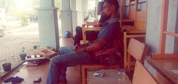 Side view of a couple sitting on floor