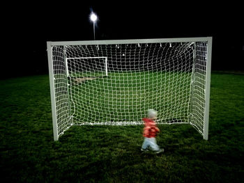 Low angle view of playing soccer on field at night