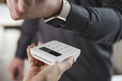 Young businessman paying with smart watch on card reader machine