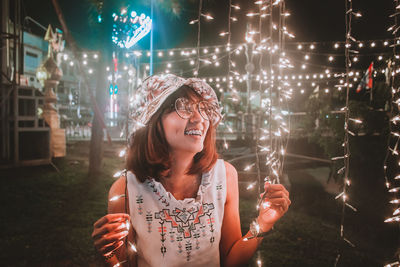 Portrait of smiling young woman at night