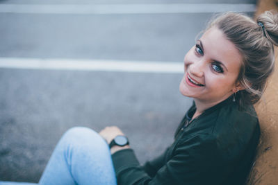 Portrait of smiling young woman sitting outdoors