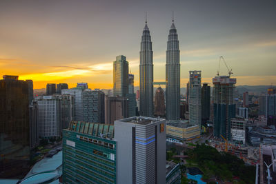 Skyscrapers against cloudy sky during sunset