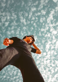 Low angle view of woman standing against sky