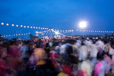 Blurred motion of people enjoying at music festival during night