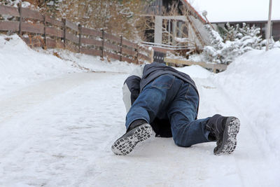 Low section of man on snow covered land