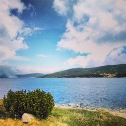 Scenic view of lake against cloudy sky