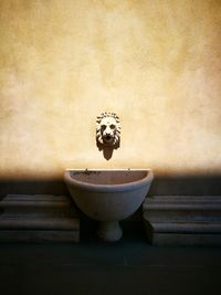 Close-up of sculpture on table against wall