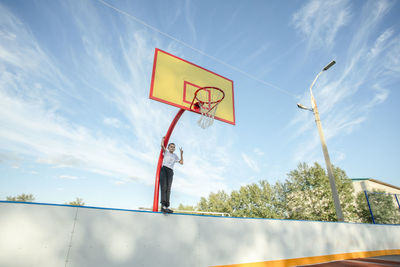 Courage at a height endurance and passion of the boy shine against the sky on the basketball court