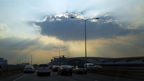 Cars on road against sky during sunset