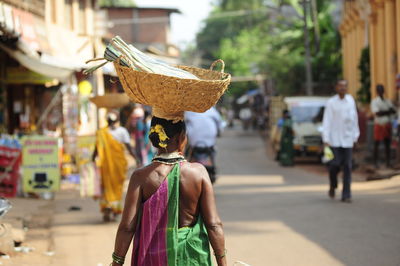 Rear view of woman with umbrella walking on street