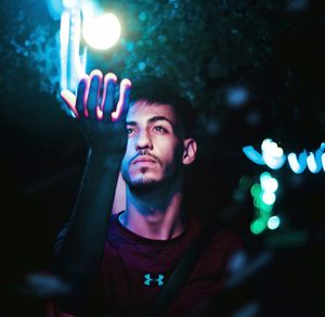 Portrait of young man looking away at night