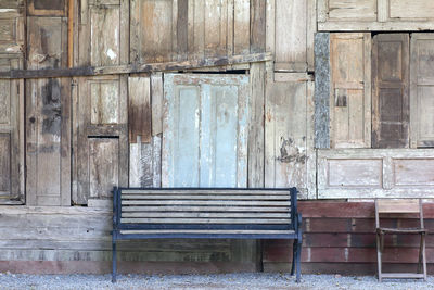 Empty bench against old building