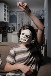 Portrait of man sitting on mask at home