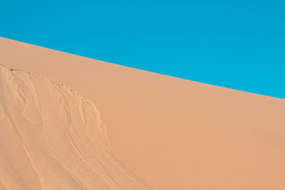 Sand dunes against clear blue sky