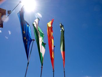 Low angle view of flags against clear blue sky