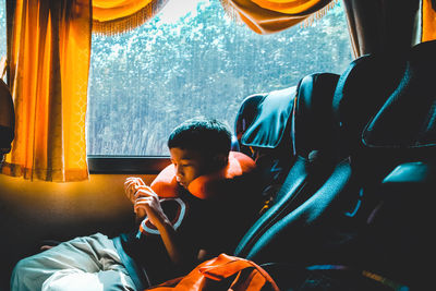 Boy watching video while sitting in bus
