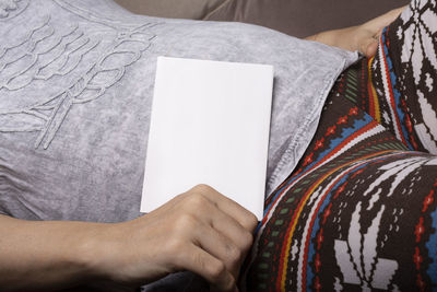 Midsection of woman holding paper