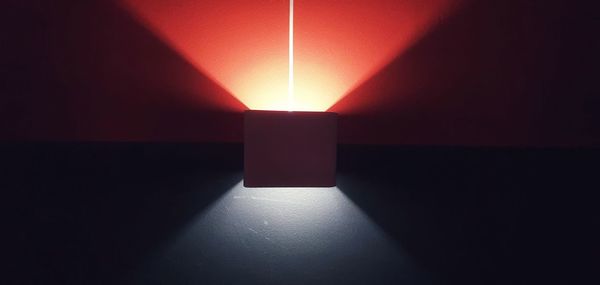 Sunlight falling on illuminated wall in darkroom