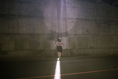 Rear view of woman standing on road