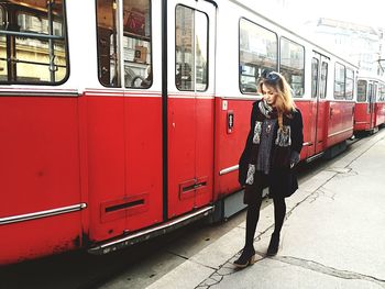 Full length of a young woman standing on tiled floor