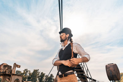 Low angle view of man looking against sky