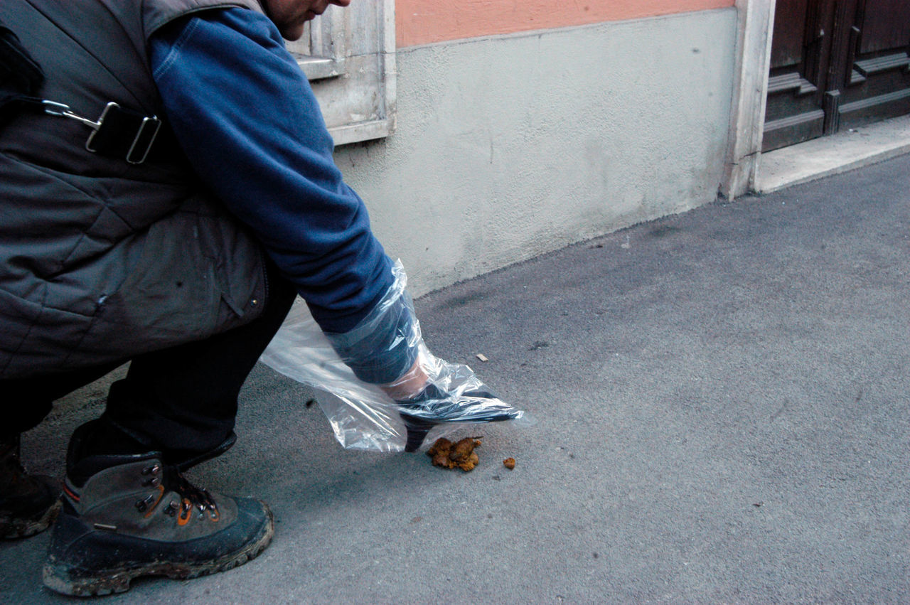 LOW SECTION OF MAN STANDING ON COBBLESTONE STREET