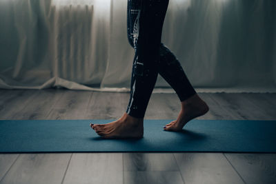 Yogic woman practicing in yoga studio details on the feet