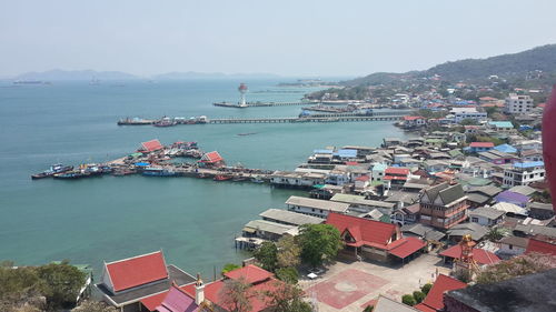 High angle view of cityscape by sea against sky