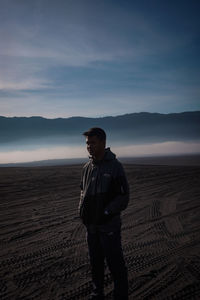 Full length of man standing on field against sky