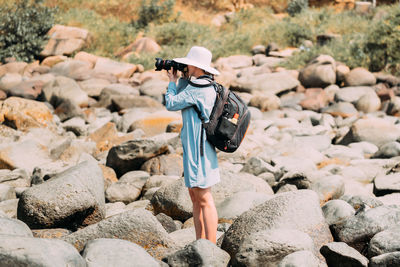 Rear view of woman standing on rock