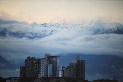 Buildings in city against sky during winter