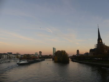 View of river and buildings against sky during sunset