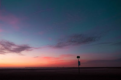 Silhouette street light against dramatic sky during sunset