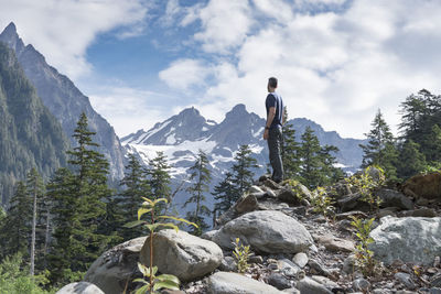 Man standing on rock against sky