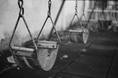 Close-up of swings hanging in playground