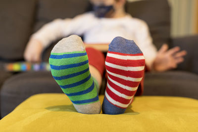 Low section of boy sitting on sofa at home