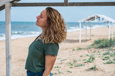 Woman with eyes closed standing at beach