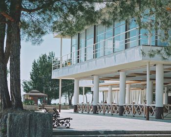 Built structure by trees in city against sky