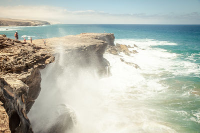 Scenic view of wave splashing beach cliff