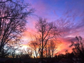 Low angle view of silhouette bare trees against romantic sky