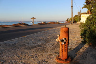 View of street by sea against clear sky