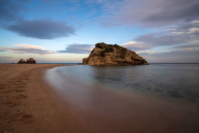 Rocks on beach against sky