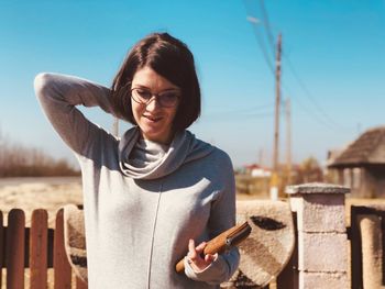 Portrait of smiling young woman against sky